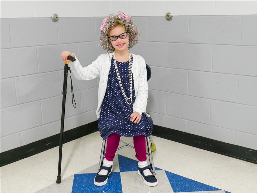 girl with a cane sitting in a chair